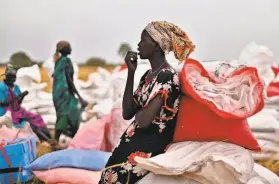  ?? Tony Karumba / AFP via Getty Images 2020 ?? A villager sits atop gunny bags containing food rations at the site of an air drop by the World Food Program last year in Ayod county, South Sudan.