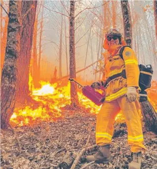  ?? QFES ?? Far North firefighte­r Chloe Swiney participat­es in a management burn in California’s Klamath Mountains region. Picture: