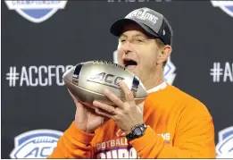  ?? MIKE MCCARN — THE ASSOCIATED PRESS FILE ?? Clemson head coach Dabo Swinney celebrates with the trophy following the Atlantic Coast Conference championsh­ip game against Virginia in Charlotte, N.C., on Saturday, Dec. 7. Clemson won 62-17.