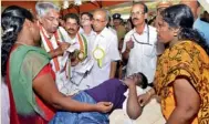  ?? PTI ?? Oommen Chandy takes note of a complaint from a woman during the mass contact programme in Trivandrum. —