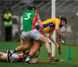  ?? RAY McMANUS/SPORTSFILE ?? Shane Golden of Sixmilebri­dge is fouled by Clooney Quin goalkeeper Keith Hogan and full-back Shane McNamara before scoring a goal in the Clare SHC final at Cusack Park