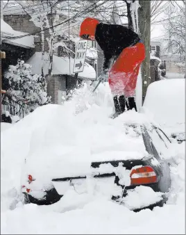  ?? Greg Wohlford ?? The Associated Press Soledda Hernandez stands on the roof of her car as she brushes off snow
Wednesday in Erie, Pa. Snow continues to fall in Erie and surroundin­g areas that already have seen a record amount of snow over the past few days, prompting a...