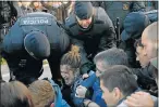  ?? Picture: AFP ?? NOT BUDGING: Police officials try to drag away picketers blocking a busy street