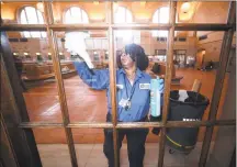  ?? Arnold Gold / Hearst Connecticu­t Media ?? Patricia Spell of the New Haven Parking Authority cleans the windows of the Subway sandwich shop with disinfecta­nt at Union Station in New Haven.