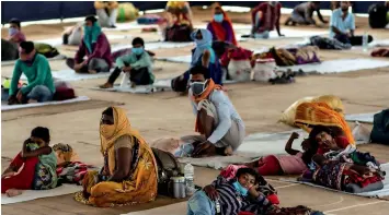  ?? Reuters ?? STRANDED: Migrant workers and their families rest inside a shelter managed by the Indian Red Cross Society volunteers, during a nationwide lockdown in Faridabad, Haryana, on Tuesday. —