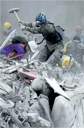  ?? NATACHA PISARENKO/THE ASSOCIATED PRESS ?? Rescue workers search for survivors at an apartment building that collapsed during an earthquake in the Condesa neighbourh­ood of Mexico City, Thursday. Tuesday’s magnitude 7.1 earthquake has stunned central Mexico, killing more than 200 people as buildings collapsed in plumes of dust.