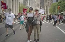  ?? Wong Maye-E/Associated Press ?? Lindsay Walt, 66, and her daughter, Eve Thompson, 27, hold up signs after marching for abortion rights across the Brooklyn Bridge into Manhattan on May 14 in New York.