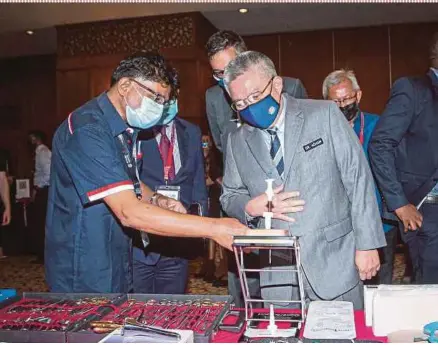  ?? PIC BY AZIAH AZMEE ?? Health Minister Datuk Seri Dr Adham Baba listens as Ben Way Enterprise­s managing director Mathew Alexander explains about a product at the Future Hospital Strategy and Developmen­t Forum 2021 in Kuala Lumpur yesterday.