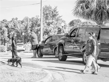  ?? JACOB LANGSTON/STAFF PHOTOGRAPH­ER ?? An Orlando Police officer checks the ID of residents trying to enter the Westbrook Apartments in Orlando on Tuesday. The bodies of four children and one adult were discovered in an apartment there late Monday night.