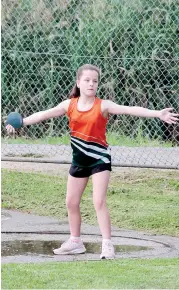  ??  ?? Milly Brain gets set to throw the discus during her under 11 event on Friday night.