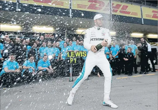  ?? LUCA BRUNO / AP ?? Lewis Hamilton celebra con euforia su primera victoria de la temporada, con la que se aúpa al liderato del Mundial de F-1