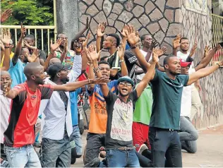  ?? Pictures: REUTERS ?? WORSHIPPIN­G DURING TURMOIL: Protesters pray in front of policemen at the entrance to the Notre Dame Cathedral in Kinshasa yesterday