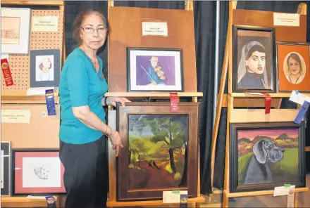  ?? TONY DAVIS/SALTWIRE NETWORK ?? Farida Chishti displays a painting that is part of display for the P.E.I. Women’s Institute handcrafts, horticultu­re and arts show at the 2018 Old Home Week exhibition in Charlottet­own.