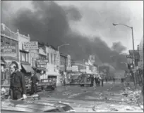  ?? THE ASSOCIATED PRESS FILE ?? Detroit police check buildings along a section of 12th Street, about three miles from downtown Detroit following racial riots which broke out in the city.