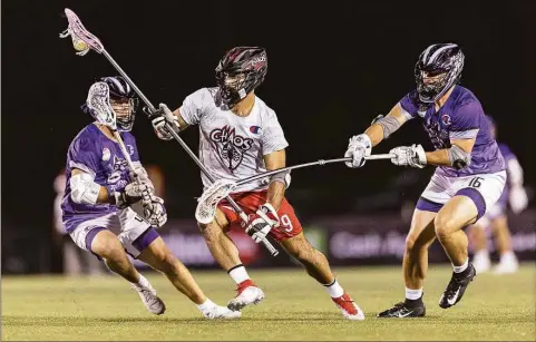  ?? Premier Lacrosse League / Contribute­d photo ?? New Fairfield’s CJ Costabile (9) of the Chaos splits a pair of opponents during a Premier Lacrosse League game against the Waterdogs on June 24.