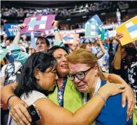  ??  ?? Carrie Pugh, left, Katrina Mendiola and Mayors Wegmann cry as Hillary Clinton officially becomes the first woman to be the presidenti­al nominee of a major U.S. political party during the second-day session of the Democratic National Convention in...
