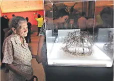  ??  ?? Catalina Solís, de 83 años, mientras aprecia la corona de espinas que se mantuvo en exposición.