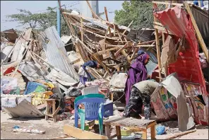  ?? (AP/Farah Abdi Warsame) ?? Somalis in Mogadishu salvage goods Saturday after shops were destroyed in a car-bomb attack.