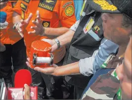  ?? Fauzy Chaniago ?? The Associated Press A member of the National Transporta­tion Safety Committee holds the flight data recorder from the crashed Lion Air jet as Chief of National Search and Rescue Agency Muhammad Syaugi speaks Thursday during a press conference on board of the research ship Baruna Jaya anchored in the waters of Tanjung Karawang, Indonesia.