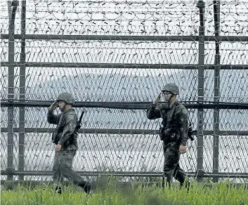  ?? AHN YOUNG-JOON/THE ASSOCIATED PRESS ?? South Korean army soldiers salute as they patrol along the barbed-wire fence in South Korea’s Paju, near the border with North Korea, Monday. South Korea offered Monday to talk with North Korea to ease animositie­s along their tense border and resume...