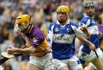  ??  ?? Wexford midfielder Eoin Quigley breaking away from Joe Fitzpatric­k of Laois.