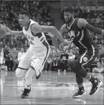  ?? The Associated Press ?? DRIVE BY: Milwaukee Bucks forward Giannis Antetokoun­mpo, left, drives past Indiana’s Paul George during the second half of an NBA basketball game Friday night in Milwaukee. The Bucks won 99-85.