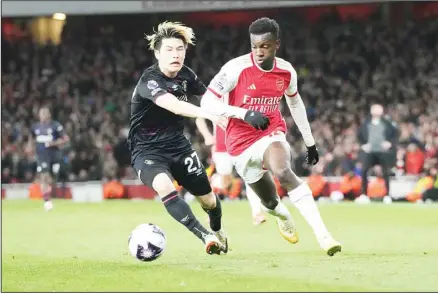  ?? ?? Luton Town’s Daiki Hashioka (left), challenges for the ball with Arsenal’s Eddie Nketiah during the English Premier League soccer match between Arsenal and Luton Town at the Emirates Stadium, London. (AP)