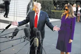  ?? Evan Vucci ?? The Associated Press First lady Melania Trump looks on as President Donald Trump speaks with reporters Friday before departing the White House for a trip to Asia.