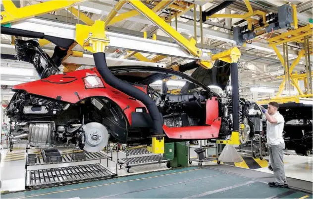  ?? Reuters ?? ↑ A worker on the production line of Bentley’s manufactur­ing facility in Crewe, Britain.