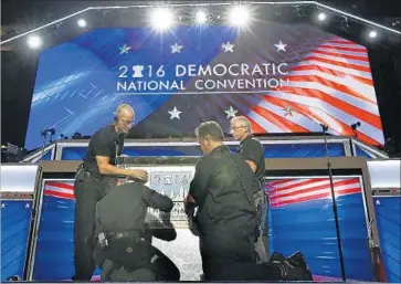  ?? Photograph­s by Carolyn Cole Los Angeles Times ?? A CREW works on the podium for the Democratic National Convention in Philadelph­ia. The set is more approachab­le and economical-looking than the GOP’s sleeker, more futuristic design in Cleveland last week.
