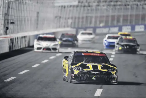  ?? Jared C. Tilton / Getty Images ?? Kyle Busch, driver of the no. 54 App State Class of 2020 Toyota, leads a pack of cars during Monday night’s Alsco 300 at Charlotte Motor Speedway.