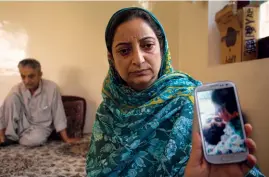  ??  ?? WHO KILLED HIM?The slain Abdul Ahad’s wife Bilquees shows a picture of him on her phone