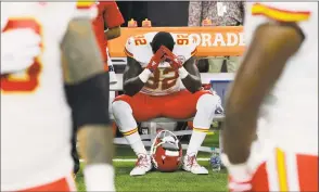  ?? Associated Press file photo ?? Kansas City Chiefs linebacker Tanoh Kpassagnon sits on the bench during the national anthem before an October NFL game against the Houston Texans. NFL owners have approved a new policy aimed at addressing the firestorm over national anthem protests, permitting players to stay in the locker room during the “The Star-Spangled Banner,” but requiring them to stand if they come to the field.