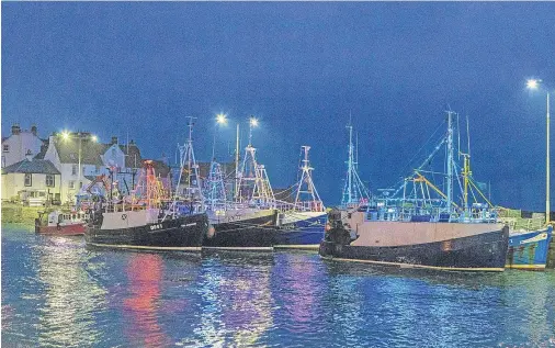  ?? Picture: Steven Brown. ?? Fishing boats at Pittenweem harbour are decorated with colourful lights for Christmas time.