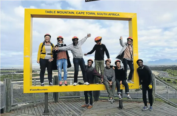  ?? Pictures: Angus Begg ?? THEY’VE BEEN FRAMED The tour group with Mzukisi Lembeni. third from left, next to Thabang Bala, and Mxolisi Ngema, far right, in the Table Mountain Frame on Lookout Hill.