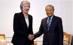  ??  ?? Dr Mahathir (right) shakes hands with May during a bilateral meeting. — Bernama photo