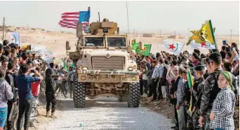  ?? — AFP ?? Syrian Kurds gather around as US troops start withdrawin­g from the areas.