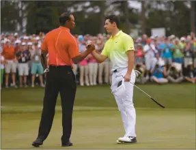  ?? David J. Phillip/AP ?? Tiger Woods, left, shakes hands with Rory McIlroy, of Northern Ireland, on the 18th hole during the fourth round of the Masters golf tournament Sunday, April 12, 2015, in Augusta.