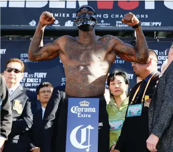  ?? PHOTOS: DAMIAN DOVARGANES/AP ?? WBC heavyweigh­t champ Deontay Wilder dons a mask during the official weigh-in ceremony Friday at Staples Center in Los Angeles, ahead of his bout tonight against Tyson Fury.