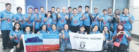  ??  ?? Dzulkarnai­n (standing centre with glasses) together with archers and coaches showing their support in the fight against illegal poaching of pangolins.They travelled to the national capital while flying the campaign's colours and will be wearing the shirts throughout the championsh­ip to help spread awareness for the cause.