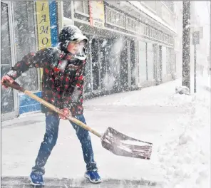  ?? COLIN CHISHOLM ?? Raymond Hart, 12, shovels the entryway in front of Hopper’s Jewellers in Windsor, NS, during a Nor’Easter on March 22.