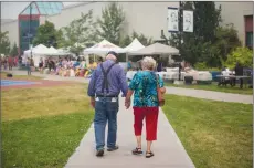  ?? Canadian Press photo ?? Wildfire evacuees McLean Rislund, 80, and June Rislund, 81, from Forest Grove near 100 Mile House, walk to an evacuation registrati­on centre in Kamloops, B.C., on Monday.