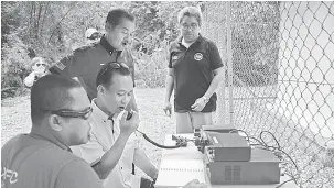  ??  ?? PELUANG TEROKAI: Dr Julyus sedang cuba menggunaka­n radio HF disaksikan oleh Liew (dua kanan) di stesen rumah api Tanjong Lobang.