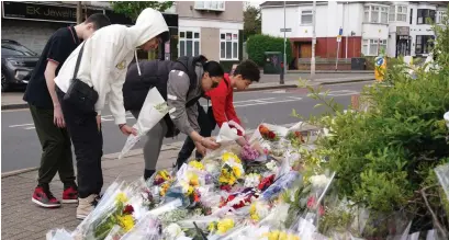  ?? ?? People lay flowers at the end of Laing Close in Hainault, near where 14-year-old Daniel Anjorin was killed in a sword attack that saw four others injured, including two Metropolit­an Police officers. Image: PA