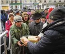  ?? EFREM LUKATSKY / AP ?? Residents stand in a bread line in Bakhmut, Ukraine, Friday. Ukrainians might soon be without power for four hours a day.
