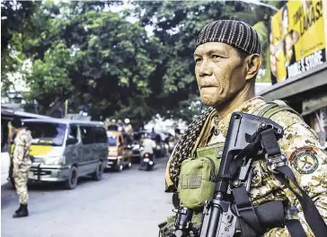  ?? FERDINANDH CABRERA/AFP ?? Moro Islamic Liberation Front members secure a camp in Mindanao on Sunday.