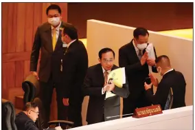  ?? (AP/Sakchai Lalit) ?? Thailand Prime Minister Prayuth Chan-ocha (center) in parliament Saturday survived a no-confidence vote in Bangkok, amid allegation­s that his government mismanaged the economy, bungled the covid-19 vaccines effort, abused human rights and fostered corruption.