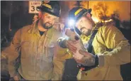  ?? ETHAN SWOPE — THE ASSOCIATED PRESS ?? Private firefighte­r Bradcus Schrandt, right, holds an injured kitten while Joe Catterson assists, at the Zogg Fire near Ono, Calif., on Sunday, Sep. 27.