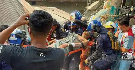  ?? (Foto ihsan NADMA) ?? Pasukan SMART mengeluark­an mangsa yang masih hidup dalam operasi SAR.