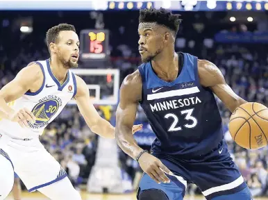  ?? AP ?? Minnesota Timberwolv­es’ Jimmy Butler (right) drives the ball against Golden State Warriors’ Stephen Curry (30) during the first half of an NBA basketball game on Wednesday night in Oakland, California.